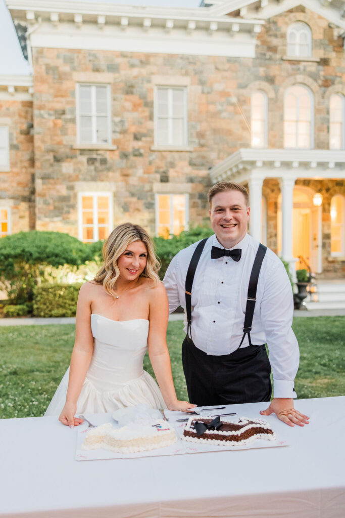 Bride and groom pose with Fudgie the Whale cakes